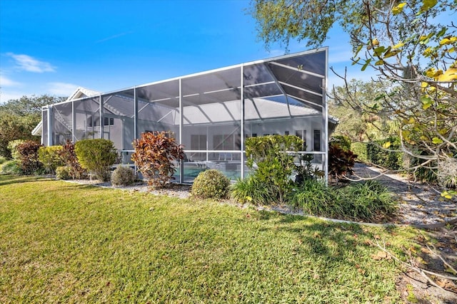 back of property with a yard and a lanai