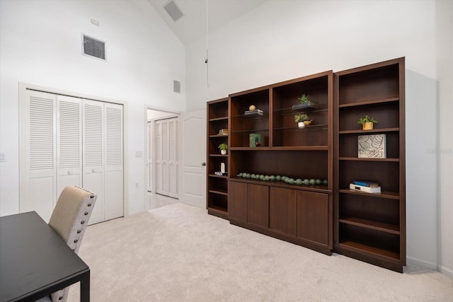 office space with high vaulted ceiling and light colored carpet