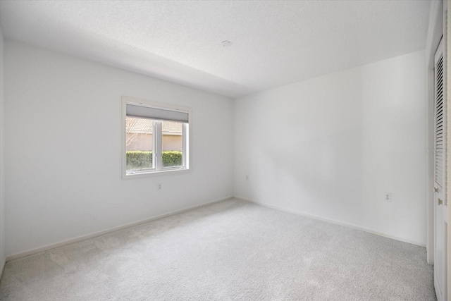 unfurnished room with carpet floors and a textured ceiling