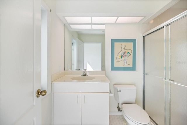 bathroom with vanity, a shower with shower door, and toilet