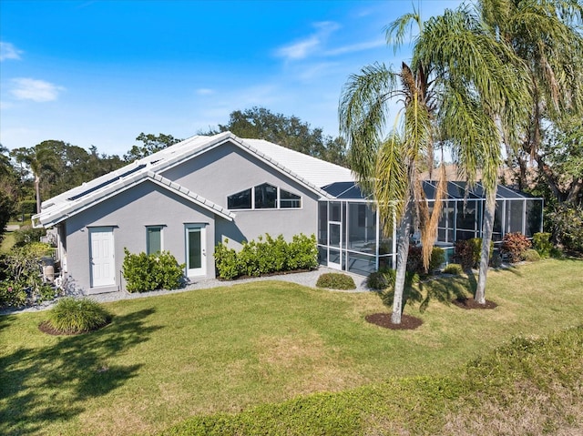 back of property with a yard and glass enclosure