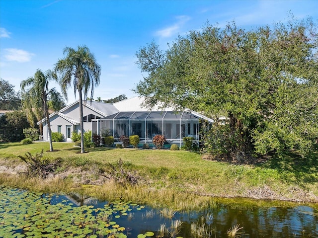 back of house with a yard, a water view, and glass enclosure