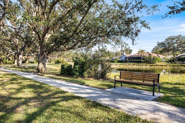 view of home's community with a water view and a lawn