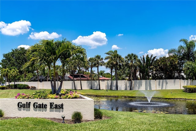 exterior space featuring a lawn, fence, and a water view