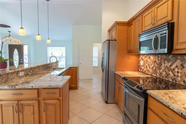 kitchen with tasteful backsplash, light stone countertops, light tile patterned flooring, stainless steel appliances, and a sink