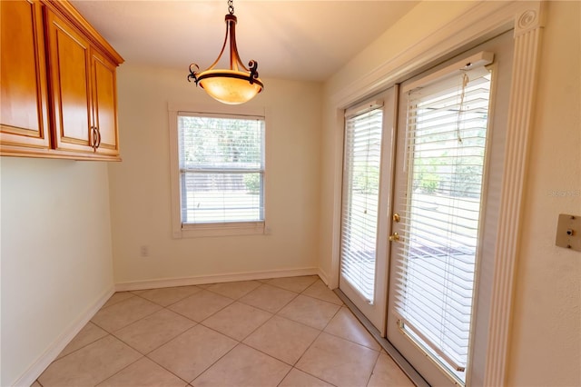 unfurnished dining area with light tile patterned flooring and baseboards