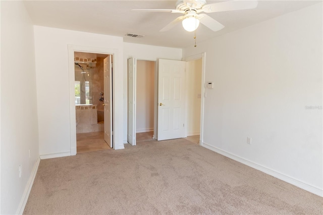 unfurnished bedroom featuring a ceiling fan, baseboards, visible vents, ensuite bath, and carpet flooring