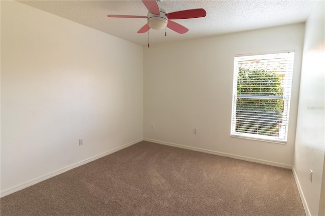 carpeted empty room with a ceiling fan, baseboards, and a textured ceiling