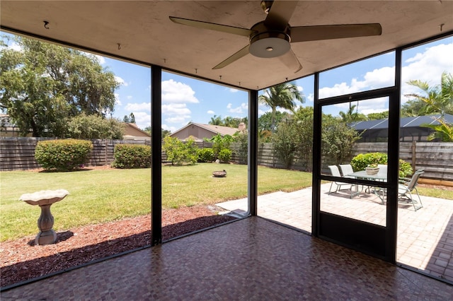 unfurnished sunroom with a ceiling fan