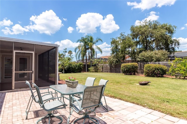 view of patio / terrace featuring outdoor dining space, fence, and a sunroom