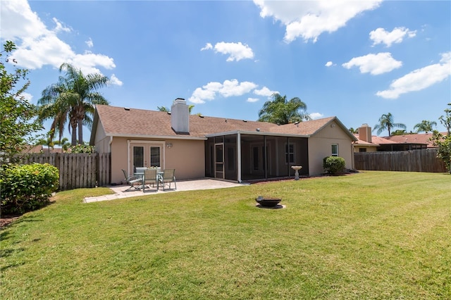 rear view of house featuring a patio, a yard, a fenced backyard, and a sunroom