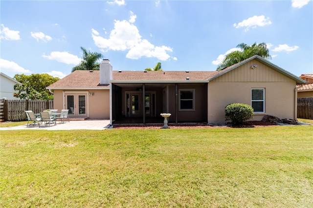 rear view of house featuring a yard, french doors, a patio, and fence