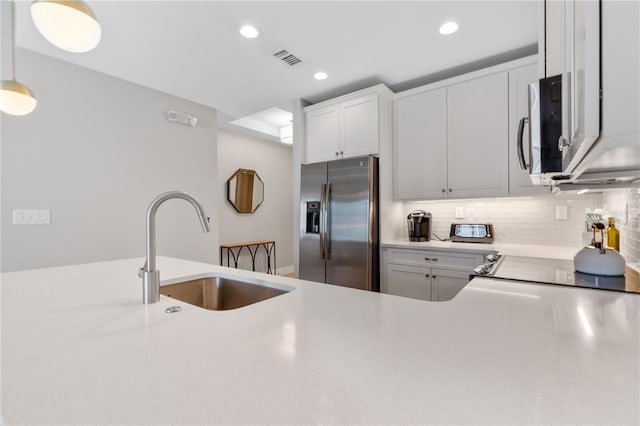 kitchen featuring stainless steel appliances, sink, white cabinets, and decorative backsplash