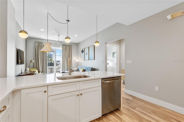 kitchen featuring white cabinetry, dishwasher, sink, and decorative light fixtures