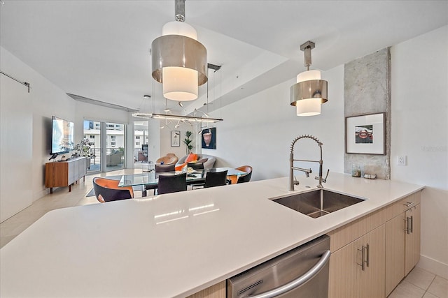 kitchen featuring pendant lighting, sink, stainless steel dishwasher, kitchen peninsula, and light brown cabinets