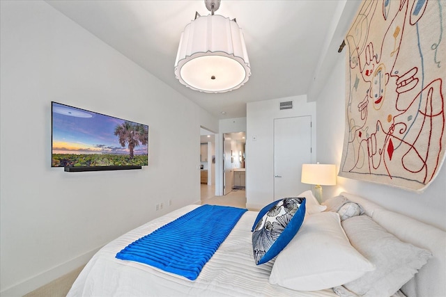 bedroom featuring light carpet and ensuite bath