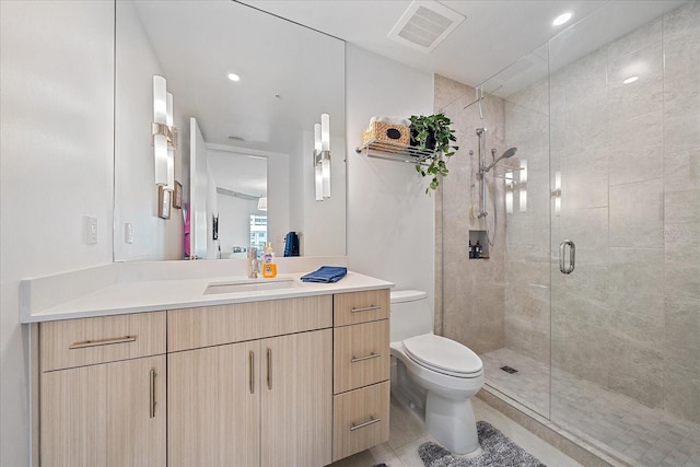 bathroom with walk in shower, vanity, toilet, and tile patterned flooring