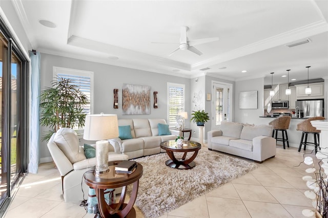 living room with light tile patterned floors, visible vents, and a raised ceiling