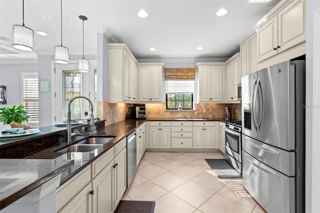 kitchen featuring light tile patterned floors, decorative backsplash, appliances with stainless steel finishes, crown molding, and a sink