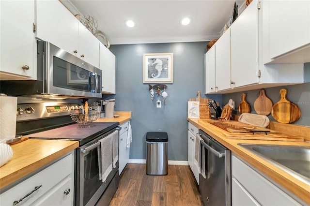 kitchen featuring dark wood-type flooring, sink, white cabinetry, crown molding, and appliances with stainless steel finishes