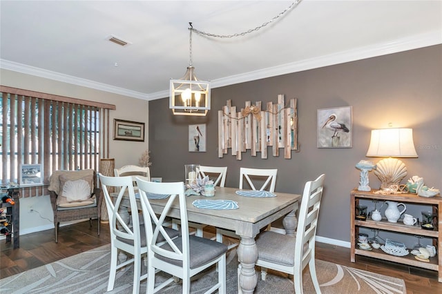 dining room featuring dark wood-type flooring, ornamental molding, and a notable chandelier