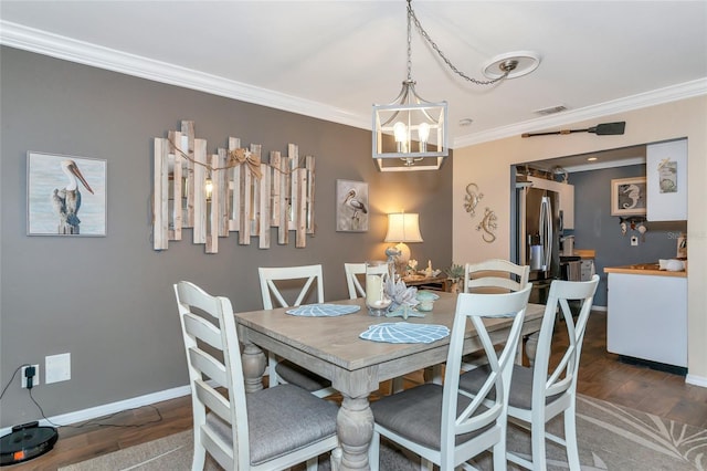 dining area with a notable chandelier, dark wood-type flooring, and ornamental molding