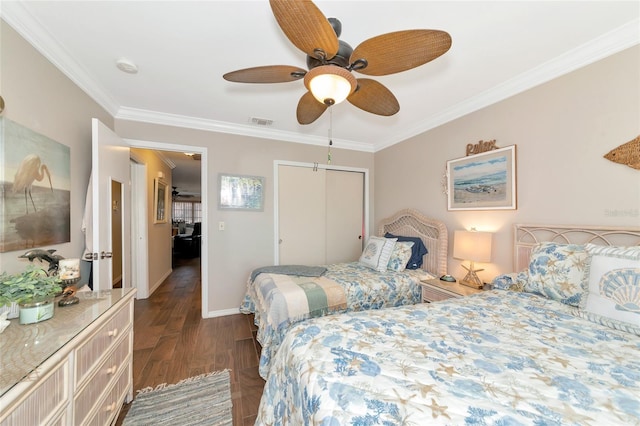 bedroom with crown molding, dark wood-type flooring, ceiling fan, and a closet