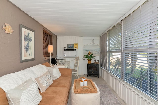 living room with a wood stove and light tile patterned floors