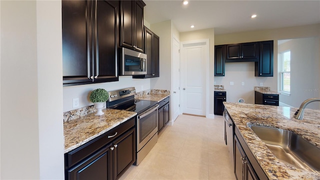 kitchen with stainless steel appliances, sink, light tile patterned floors, and light stone counters