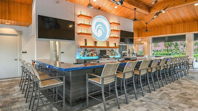 kitchen with decorative light fixtures, beamed ceiling, a breakfast bar area, kitchen peninsula, and wooden ceiling