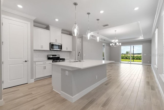26930 Lark Ct, Punta Gorda, FL 33955 - kitchen with stainless steel appliances, a sink, light wood-style flooring, a chandelier, and crown molding