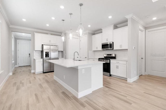26930 Lark Ct, Punta Gorda, FL 33955 - kitchen with stainless steel appliances, a sink, decorative backsplash, a center island with sink, and light wood finished floors