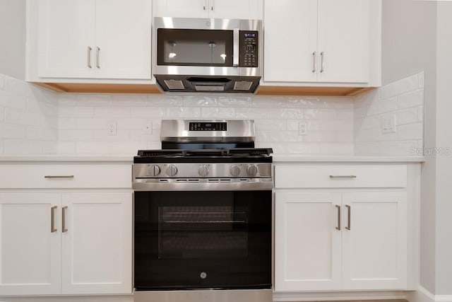 26930 Lark Ct, Punta Gorda, FL 33955 - kitchen with appliances with stainless steel finishes, white cabinets, light countertops, and backsplash
