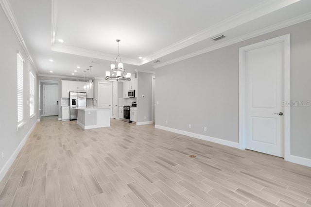 26930 Lark Ct, Punta Gorda, FL 33955 - unfurnished living room featuring a chandelier, light wood-style flooring, baseboards, a raised ceiling, and recessed lighting