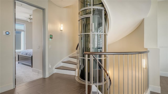 stairway featuring ceiling fan, baseboards, and wood finished floors