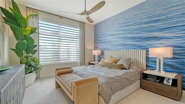 bedroom featuring light carpet, an accent wall, multiple windows, and wallpapered walls