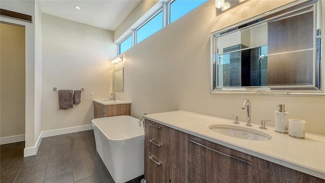 full bath featuring a stall shower, tile patterned flooring, two vanities, and a sink