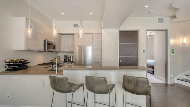 kitchen featuring stainless steel appliances, light countertops, white cabinetry, and modern cabinets