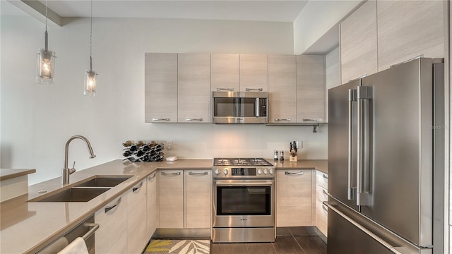 kitchen featuring stainless steel appliances, pendant lighting, a sink, and modern cabinets