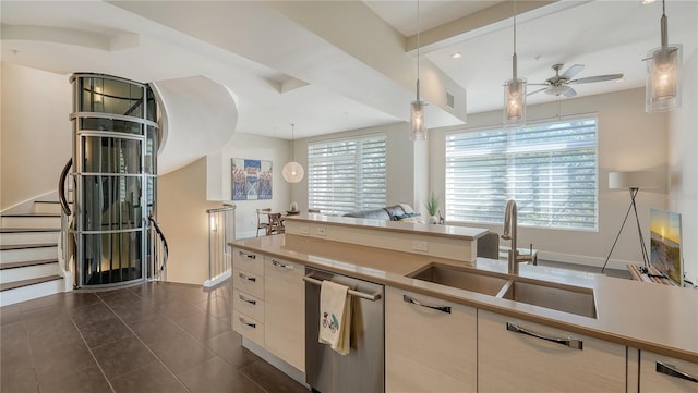 kitchen with a ceiling fan, open floor plan, hanging light fixtures, a sink, and stainless steel dishwasher