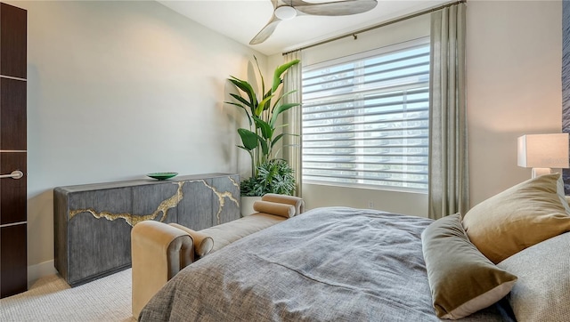 bedroom with light carpet and a ceiling fan