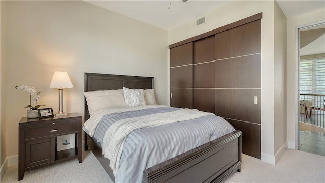 bedroom featuring light colored carpet, visible vents, and baseboards