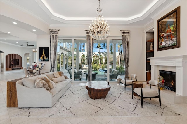 13315 Palmers Creek Ter, Lakewood Ranch, FL 34202 - living room with crown molding, ceiling fan with notable chandelier, a raised ceiling, and built in shelves