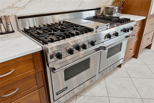 13315 Palmers Creek Ter, Lakewood Ranch, FL 34202 - kitchen featuring light tile patterned floors, decorative backsplash, and range with two ovens