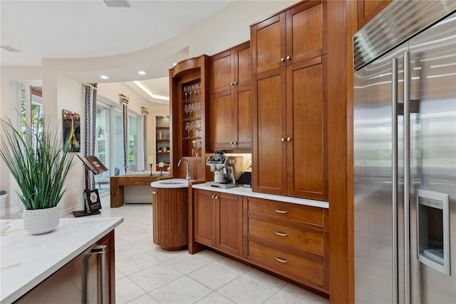 13315 Palmers Creek Ter, Lakewood Ranch, FL 34202 - kitchen featuring high end fridge, light stone counters, and light tile patterned flooring
