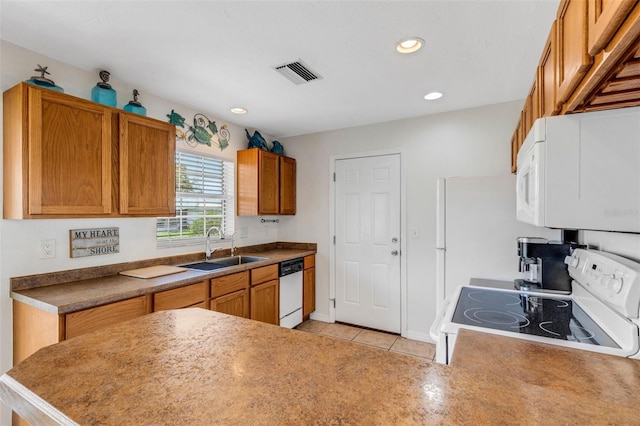 kitchen featuring light tile patterned flooring, white appliances, and sink