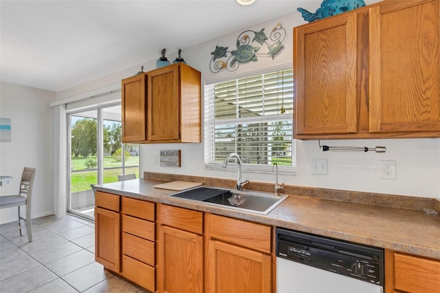 kitchen featuring plenty of natural light, dishwasher, sink, and light tile patterned floors