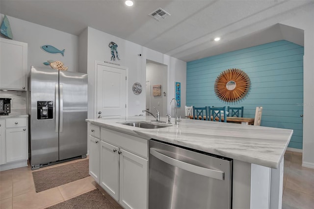 kitchen with a kitchen island with sink, sink, white cabinets, and appliances with stainless steel finishes