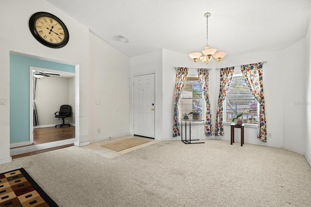 entryway featuring lofted ceiling, light carpet, and a chandelier