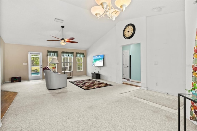 carpeted living room with ceiling fan with notable chandelier and high vaulted ceiling